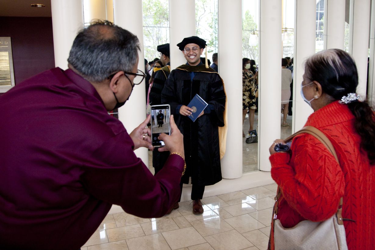 Onlookers photograph a graduate in the lobby after the ceremony.