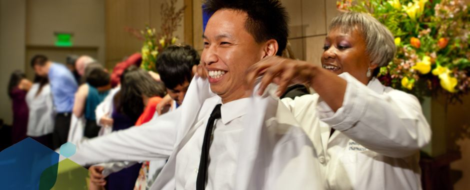 student pharmacist receiving white coat in ceremony
