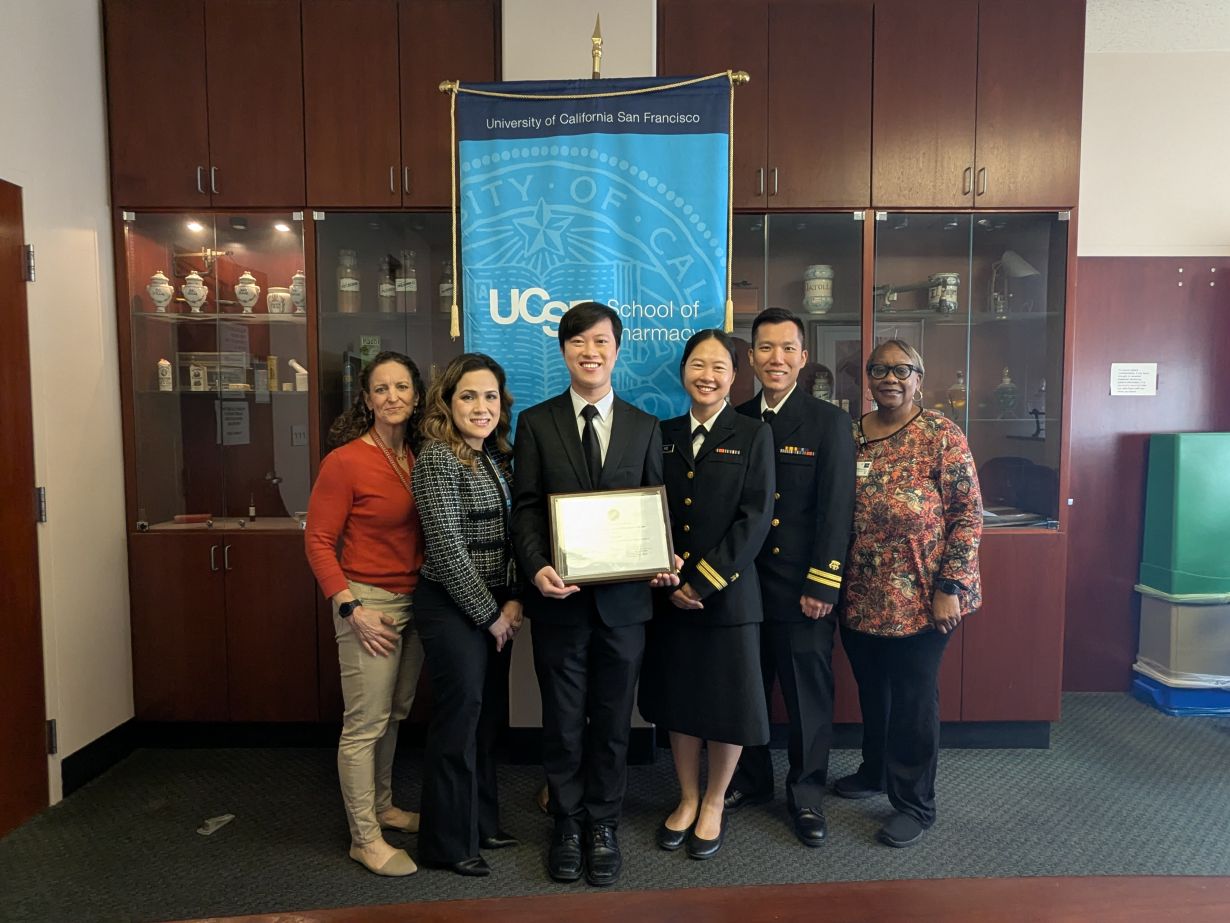 Student Emil Tran with his award, along with faculty and guests