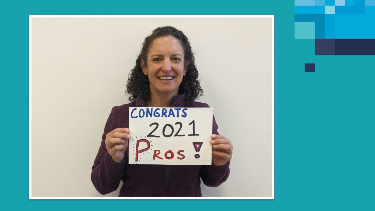 Woman holding message "Congrats 2021 Pros"