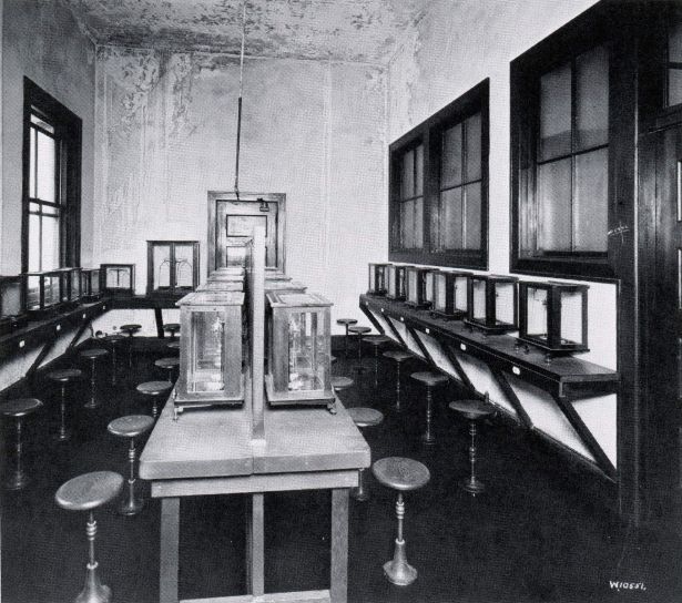 room with many seated stations for weighing materials on scales.