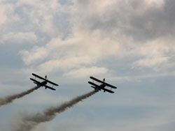 two bi-planes viewed against bright clouds