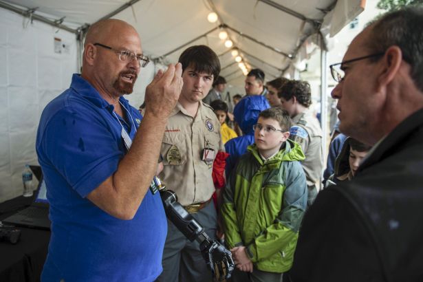 Matheny demonstrates prosthetic arm to onlookers