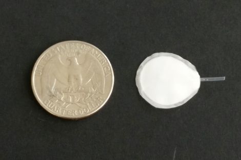 device alongside a quarter to show size