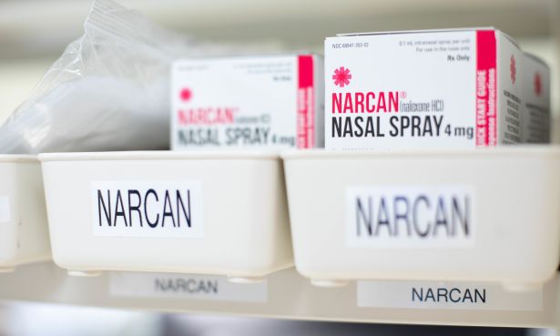 Boxes of Narcan are shown on a shelf in a pharmacy.