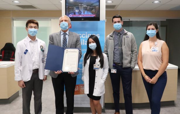 Guglielmo holds the official proclamation of Pharmacist Day in San Francisco while surrounded by PharmD students.