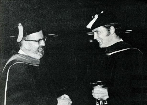Goyan shaking Fleckenstein’s hand while the graduate holds the Bowl of Hygeia.