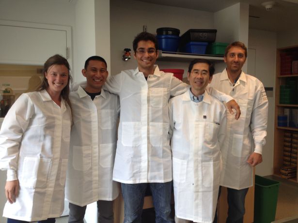 Ku in his lab coat with four other lab members.