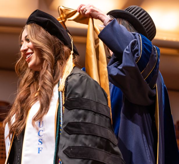 student gets hooded by Giacomini