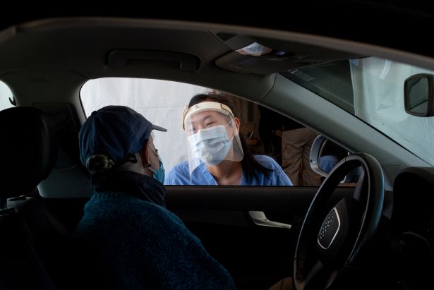 Student talking to person in a car at a COVID testing site