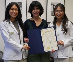 Koay (left) and Tran (right) present Dean Giacomini (center) with mayoral proclamation.