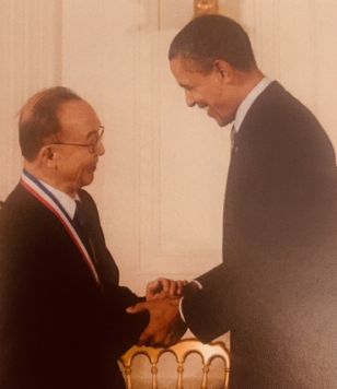 Chien wearing medal shakes hands with Obama