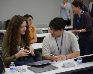 Su Oner and Hanson Hoang engage in class over a laptop.