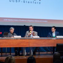 five panel speakers seated on stage.