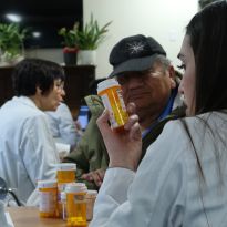 Student inspecting a patient's medication bottle