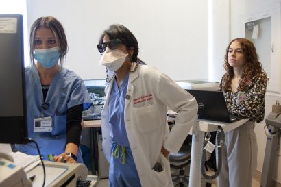 Kukreja and Taylor review data on a monitor while Gordon looks on.