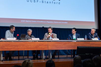 five panel speakers seated on stage.