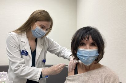 Molina holds a vaccine dose against Giacomini’s arm