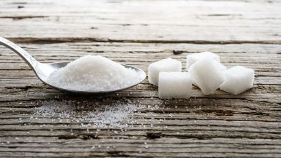 spoon of sugar and sugar cubes on a table