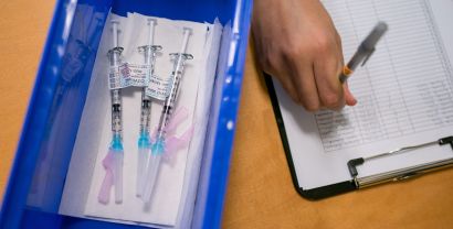 syringes next to a record-keeping clipboard
