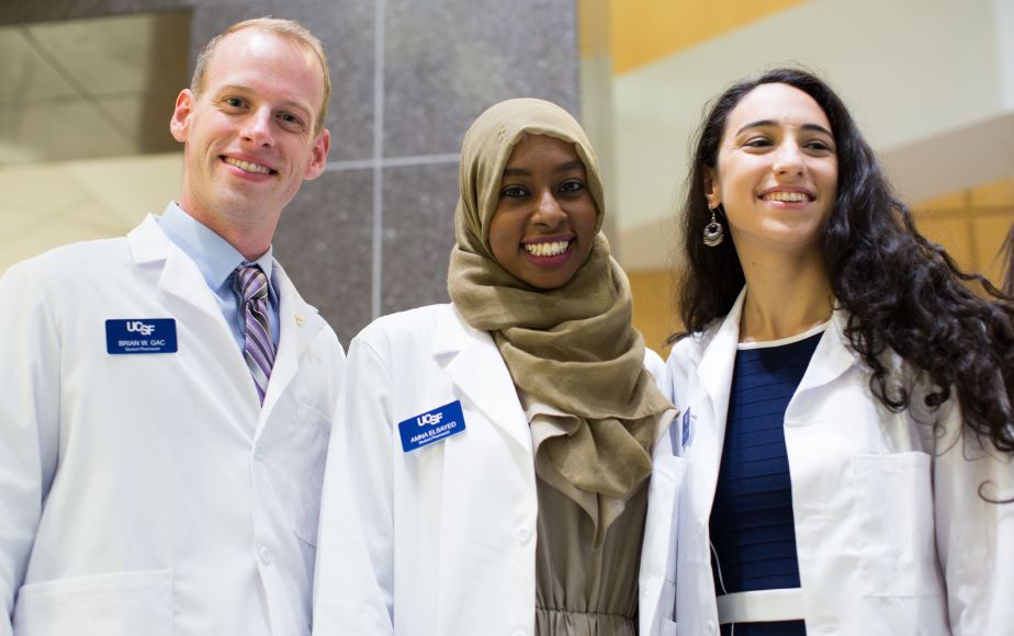 three students in white coats