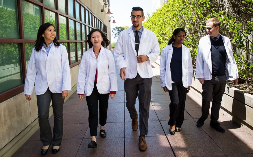 students walking in white coats