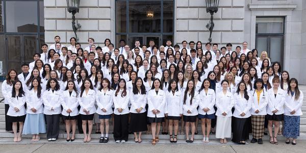 UCSF School of Pharmacy Class of 2029 assembled in white coats outside