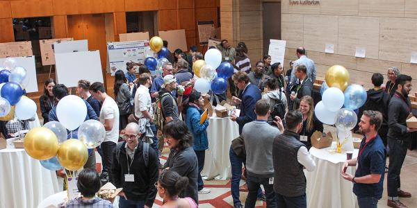 people mingle in the atrium of a building at a symposium