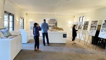 people browse scale models, posters, videos, and VR experiences.