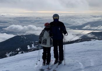 Skiers with a panoramic view behind them.