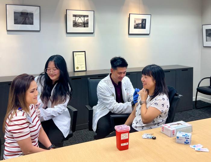 Tram Cat and Crystal Zhou getting vaccinated by PharmD students