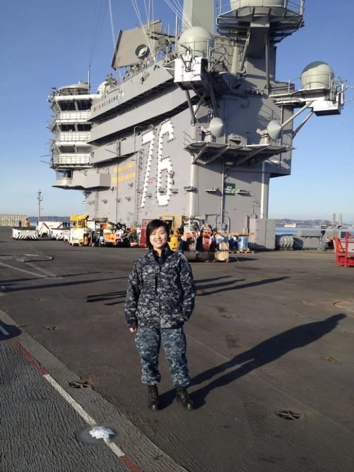 Phuong Phan in front of aircraft carrier