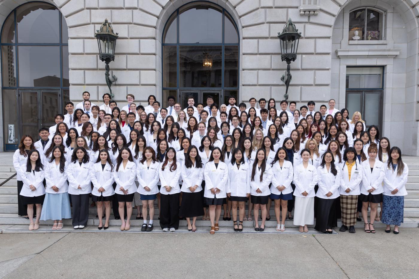 UCSF School of Pharmacy Class of 2029 assembled in white coats outside